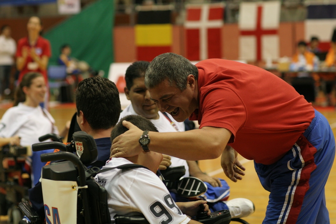 Image of a coach patting an athlete on the head